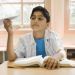 Boy in school at a desk with a paper airplane