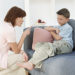 Mother pointing finger at boy age 8 or 9 in living room