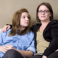 Mom sitting on couch with her teen daughter